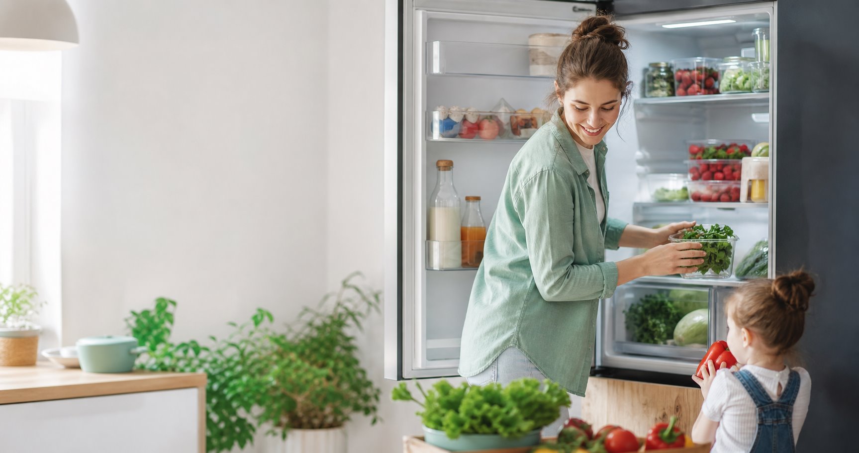 A young family lays out fresh food in the refrigerator